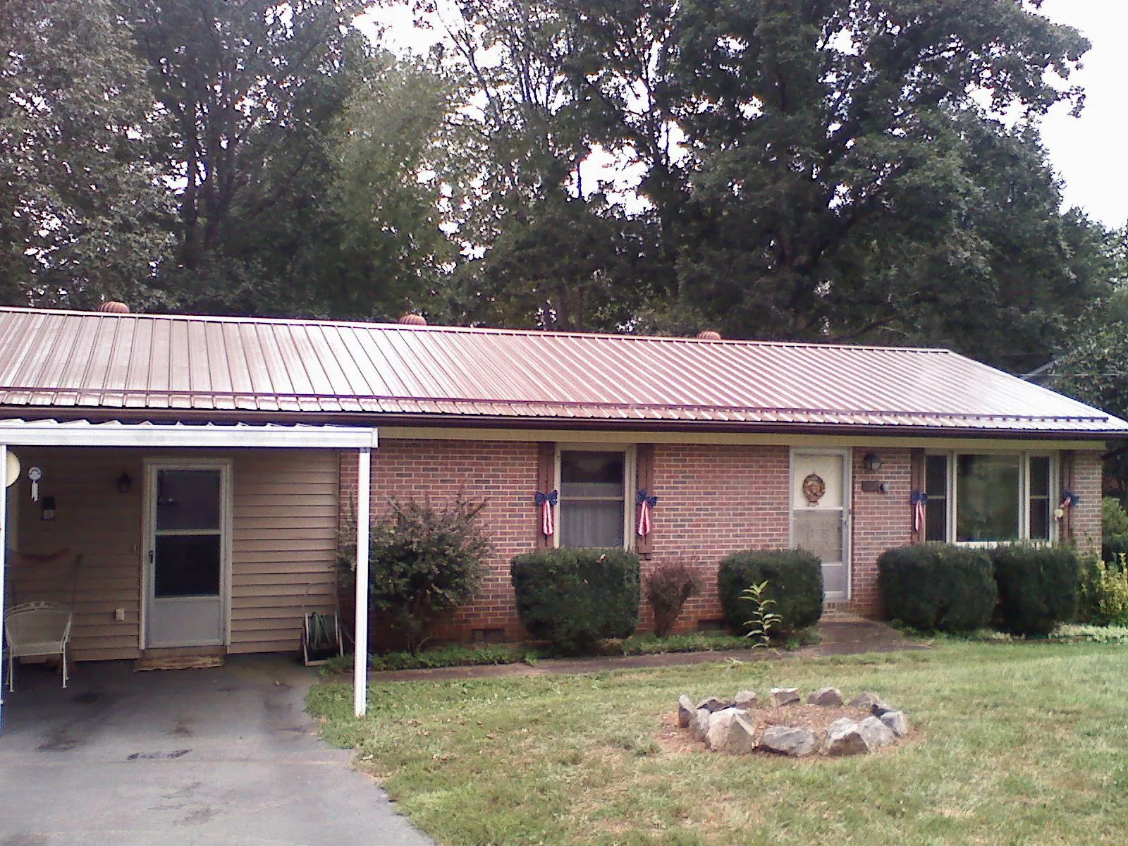 Bronze metal roof and carport on a brick ranch home — Roof Repair work by our crew in Lane